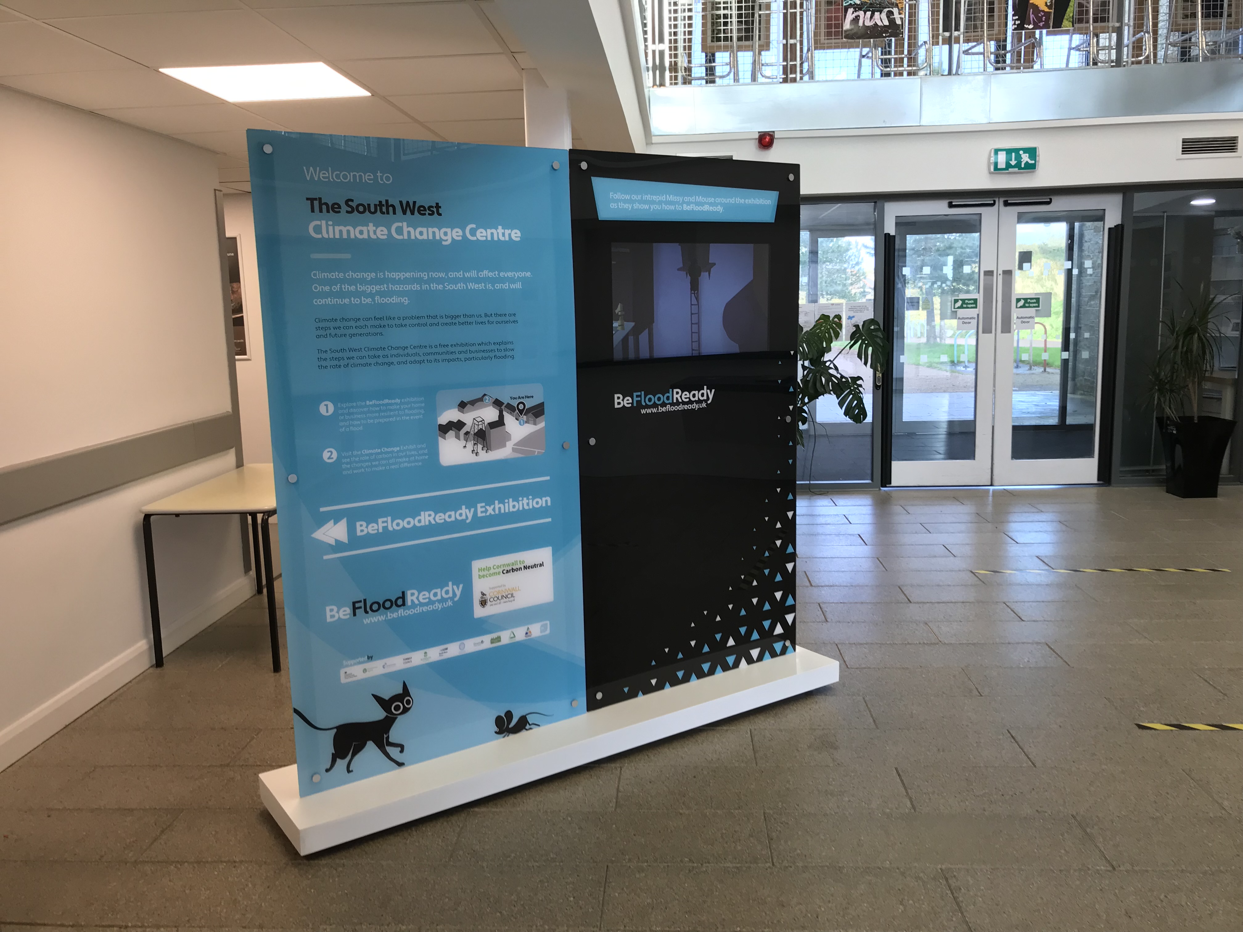 Freestanding acrylic interpretation display with integrated screen in a visitor foyer
