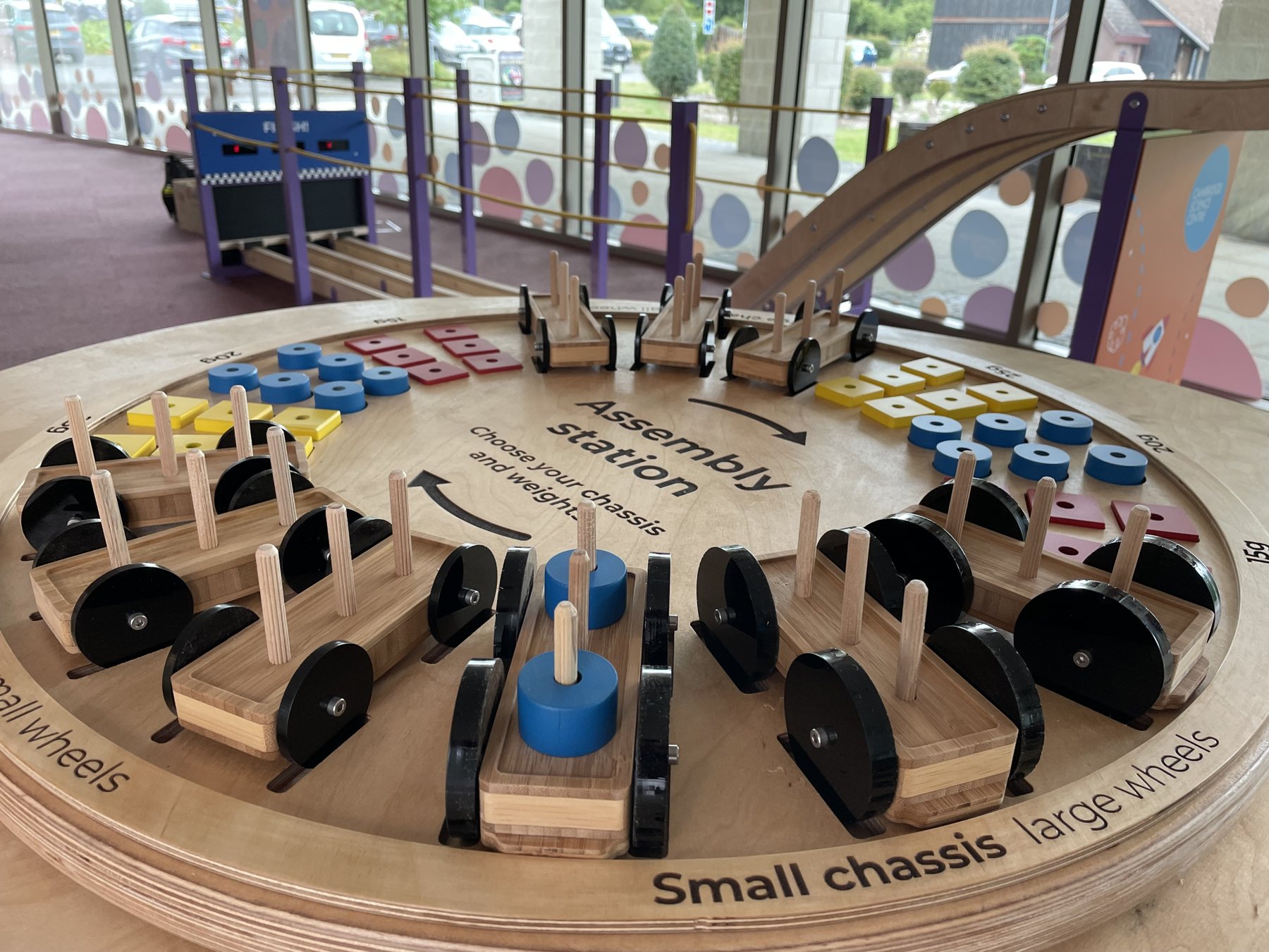 Build & Race Car Track: model cars and components arranged around the circular worktop.