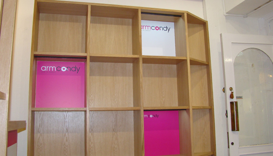Oak shelving with branded inserts and lighting in shop
