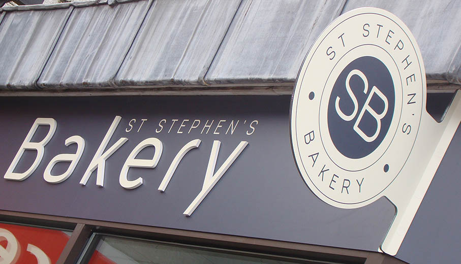 Simple projecting sign for bakery in Plymouth with printed text.