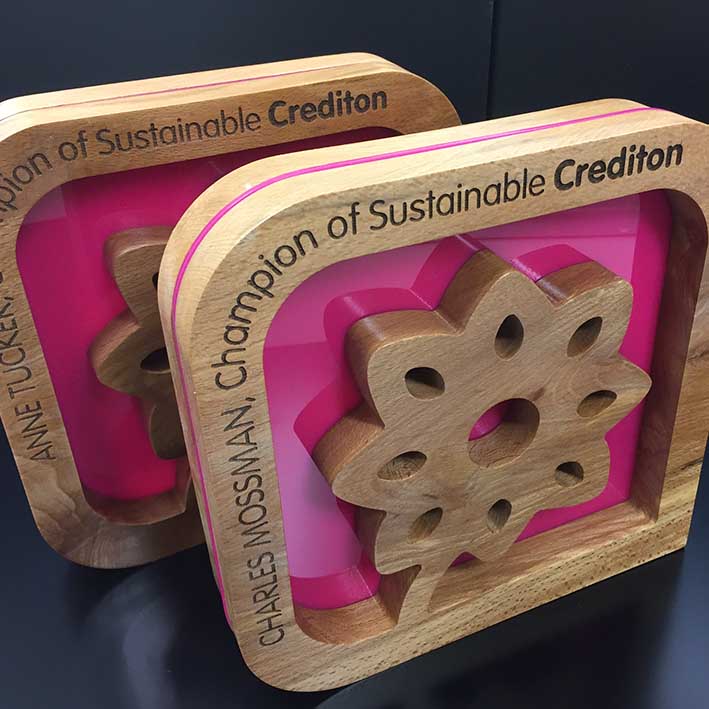 Sustainable crediton awards in Devon made with pink acrylic inlay and laser etched. 